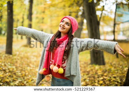 Woman with rised hands in autumn park