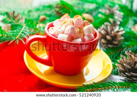 Winter Christmas decoration, fir branches and cones, marshmallows and hot drink, coffee or cacao in a cup.