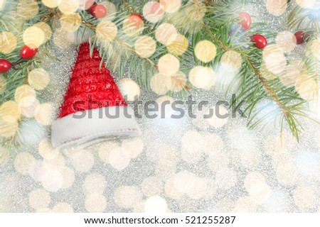 Santa hat toy and fir tree on Christmas lights background