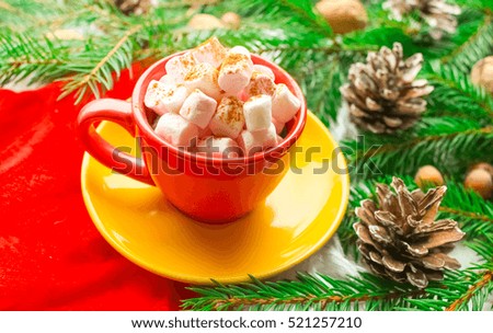 Winter Christmas decoration, fir branches and cones, marshmallows and hot drink, coffee or cacao in a cup.