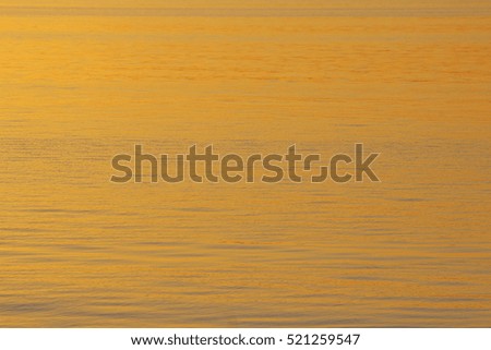 water in the river of golden rays of the setting sun in the background. gold on blue