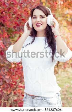 Happy young woman walking in a colorful autumn park. Girl in the autumn forest. Warm autumn.