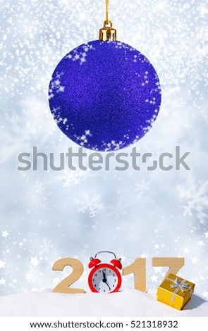 Happy new year 2017 greeting card. Alarm clock, gift and the numbers 2017 in a snowdriftrift