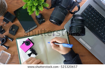 Camera's action with their accessories accompanied of a notebook and a camera reflex Royalty-Free Stock Photo #521320657