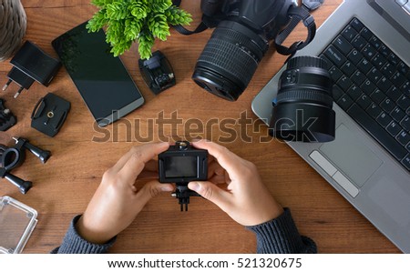 Camera's action with their accessories accompanied of a notebook and a camera reflex Royalty-Free Stock Photo #521320675