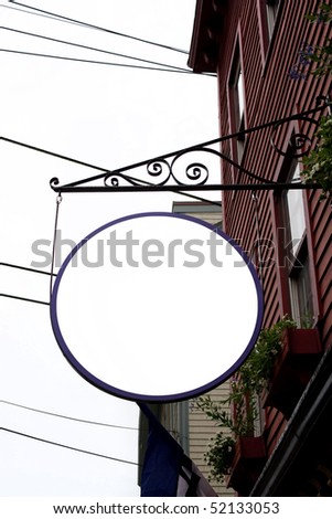 A blank circular hanging sign outside a store font or shop with copyspace for your text or logo.  Clipping path is included in the file.