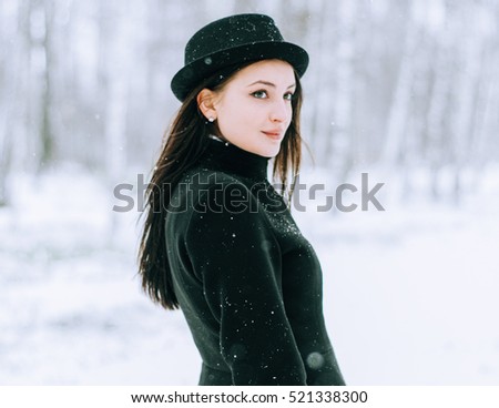 Woman winter snow nature portrait in black coat 