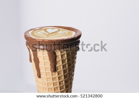 Coffee in waffle cone dipped in chocolate, latte art cappuccino, latte milk foam, latte art, isolated