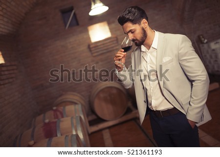 Wine maker testing wines in winery basement Royalty-Free Stock Photo #521361193