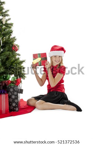 Teen girl spending time by the christmas tree isolated on white background