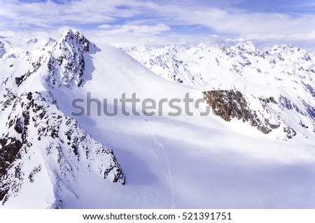 A group of skiers wandering across a glacier in Alps in Italy. Shot from Austria.