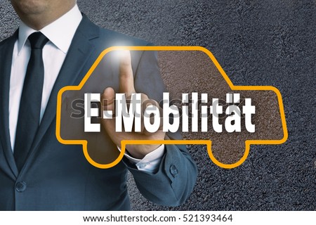 E-Mobilitaet (in german E-mobility) touchscreen is shown by businessman. Royalty-Free Stock Photo #521393464