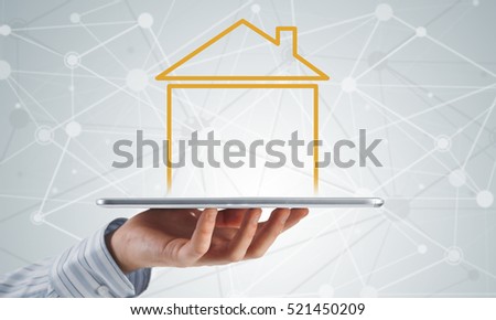 Hand holding modern tablet and house sign on screen
