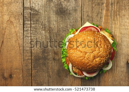 Top view gourmet  hamburger on wooden background. Fastfood meal. Vintage toned Royalty-Free Stock Photo #521473738