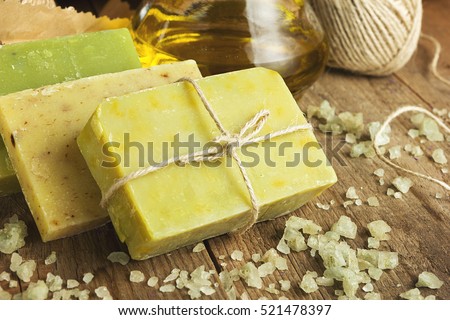 Collection of handmade, natural organic soap and cosmetic oil on wooden background. Spa products. Vintage toned Royalty-Free Stock Photo #521478397