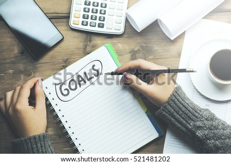 notebook is with "GOALS" text and woman and pencil Royalty-Free Stock Photo #521481202