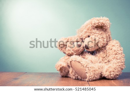 Two retro Teddy Bear toys family: parent with baby. Parenthood concept. Vintage old style filtered photo