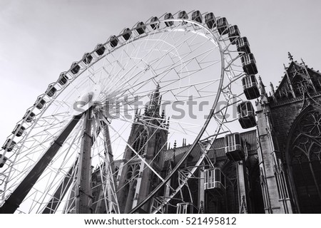 Christmas Ferris wheel in front of the cathedral of Metz. Metz (France). Black and white.