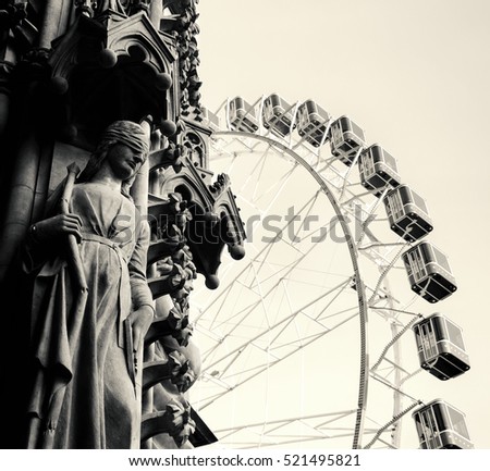 Christmas Ferris wheel in front of the cathedral of Metz (woman with covered eyes statue). Metz (France).  Black and white.