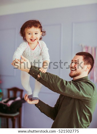 happy father plays with his cute and wonderful doughter