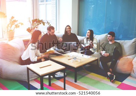 Freelance team members working together on making  researching about modern technology drone . Students share opinions during break sitting in coworking space inspiring by conversation with friends Royalty-Free Stock Photo #521540056