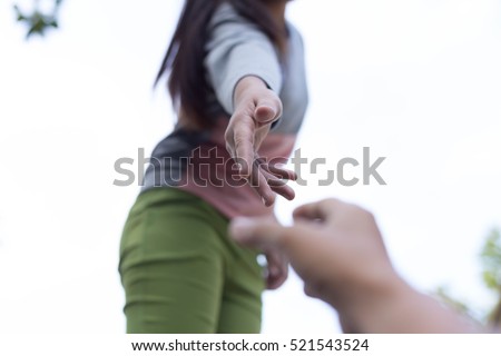 Help Concept Hands reaching out to help each other. Royalty-Free Stock Photo #521543524