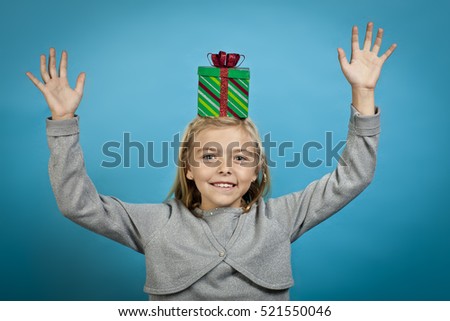 Holiday festive season theme with a cute young blonde girl isolated on blue background