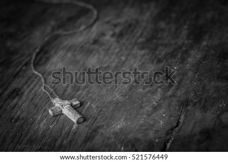 Cross on a black wooden background Black and white photography