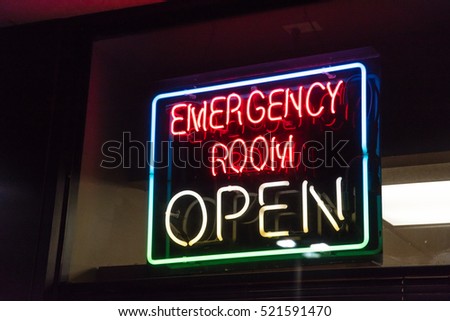 Close-up view Open neon or led sign of an emergency room illuminated at night in Houston, Texas, US. Red Emergency department entrance with neon shining signboard. Emergency healthcare service concept