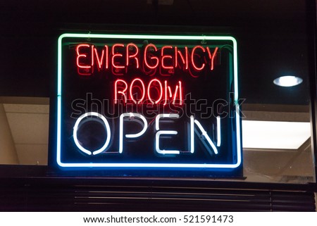 Close-up view Open neon or led sign of an emergency room illuminated at night in Houston, Texas, US. Red Emergency department entrance with neon shining signboard. Emergency healthcare service concept