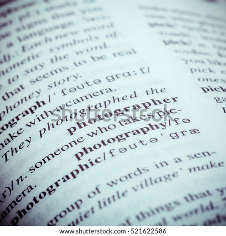Close up of old English dictionary page with word Photographer. Shallow depth of field and toned page of word Photographer on English dictionary .