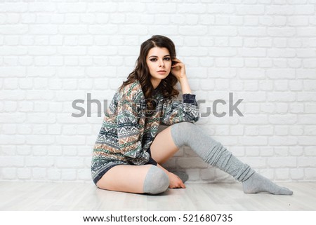 Beautiful young woman sitting on studio.