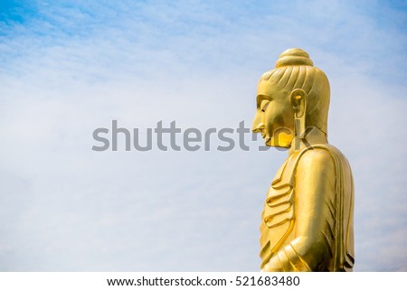 The big Buddha statue against cloudy and blue sky background.