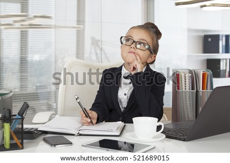 Adorable business girl (seven years old) working at the office
 Royalty-Free Stock Photo #521689015