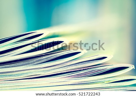 Close up edge of colorful magazine stacking with  blurry bookshelf background for publication and publishing concept , extremely shallow DOF with vintage retro color tone Royalty-Free Stock Photo #521722243