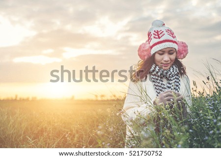 Young beautiful woman wearing winter clothing while standing enjoy with nature. Winter time concept.