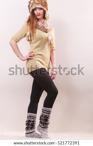 Winter fashion. Happy young woman in full length wearing fashionable wintertime clothes fur cap woolen warm socks posing