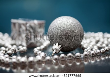 Silver gift box and Christmas ball over blue background. Magic holiday lights. Merry Christmas and a Happy New Year
