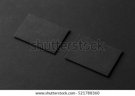 Mockup of two blank business cards at black textured background.