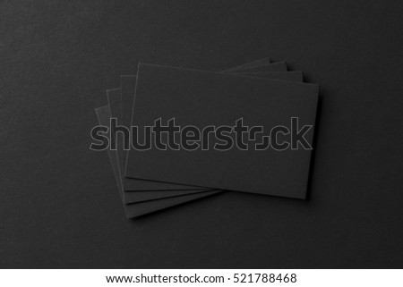 Mockup of business cards fan stack at black textured paper background.
