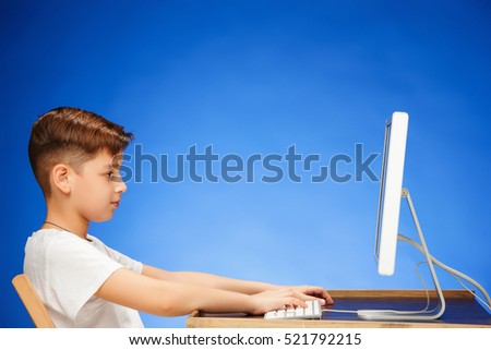 School-age boy sitting in front of the monitor laptop at studio