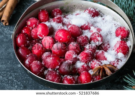 Frozen cranberries and spices in bowl, close up view, horizontal