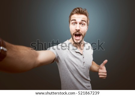 Young handsome man taking a selfie photo Royalty-Free Stock Photo #521867239