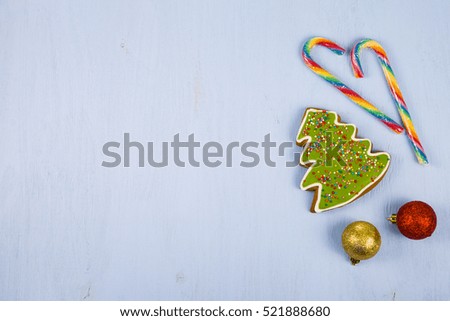 Gingerbread and candy canes on a blue wooden background. Christmas sweets and decorations