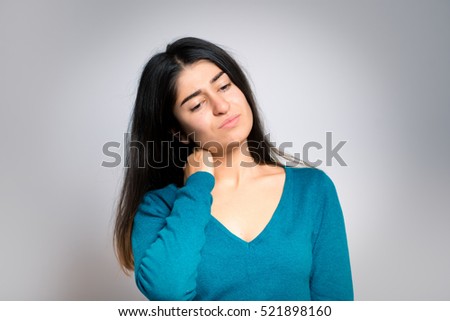 The woman has a sore neck, isolated on a gray background