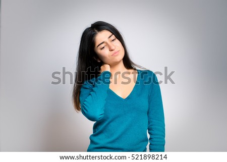 The woman has a sore neck, isolated on a gray background