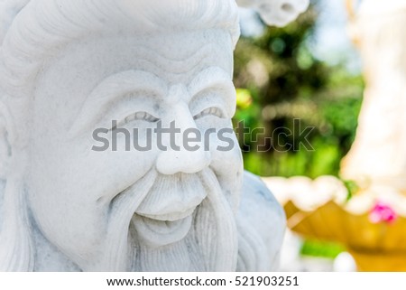 Marble statue of the old man smiling.