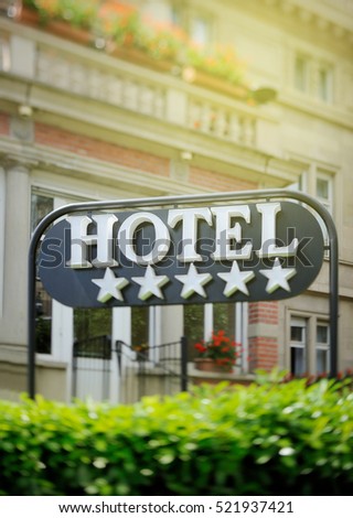 Detail of a luxury five stars hotel with beautiful building in the background on a beautiful sunny day. Tilt shift lens used to accent the word "hotel" and to emphasize the background