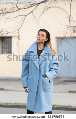 Model in blue coat with hand in he rpocket