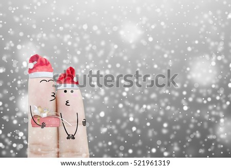 Couple finger with hat santa claus and gift on hand with snow holiday christmas art abstract background